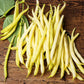 A close-up of several bright yellow Cherokee Wax beans, showcasing their smooth texture and vibrant color.