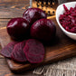 A close-up of harvested Detroit Dark Red beets, showcasing their deep red color and smooth skin.