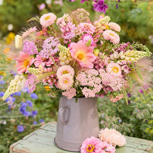 Bouquet of pink and white flowers from the pink prairie bouquet in a gray vase with a garden background