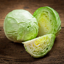 A large, round, vibrant green cabbage head of the All Seasons variety on a wooden surface.