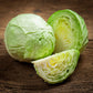 Golden Acre cabbage whole and halved on a dark background.