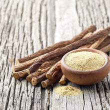 Close-up of three dried licorice roots with textured, brown skin on a light background.