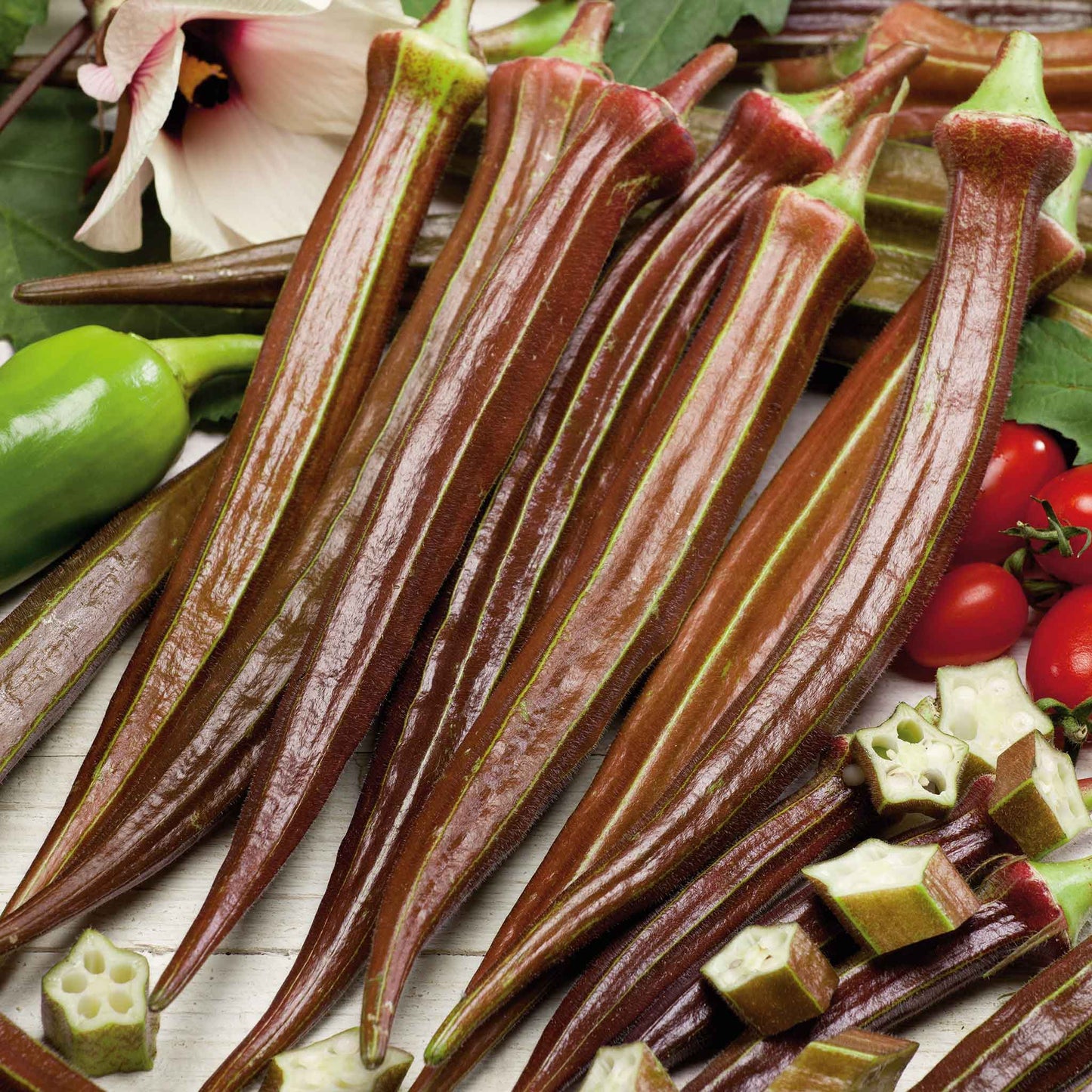 Several elongated Red Burgundy okra showing its deep red skin and green stems.