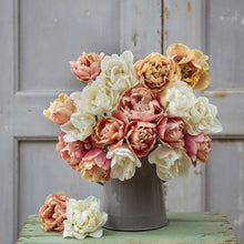 A person holding a pink and yellow bouquet from the la belle epoque and mount tacoma tulip bundle