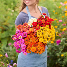 Person holding a bouquet of flowers from the zinnia lilliput series bundle in a garden setting