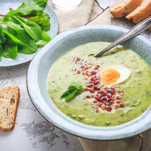 Creamy sorrel bowl dish with garnish with sorrel leaves in the background.